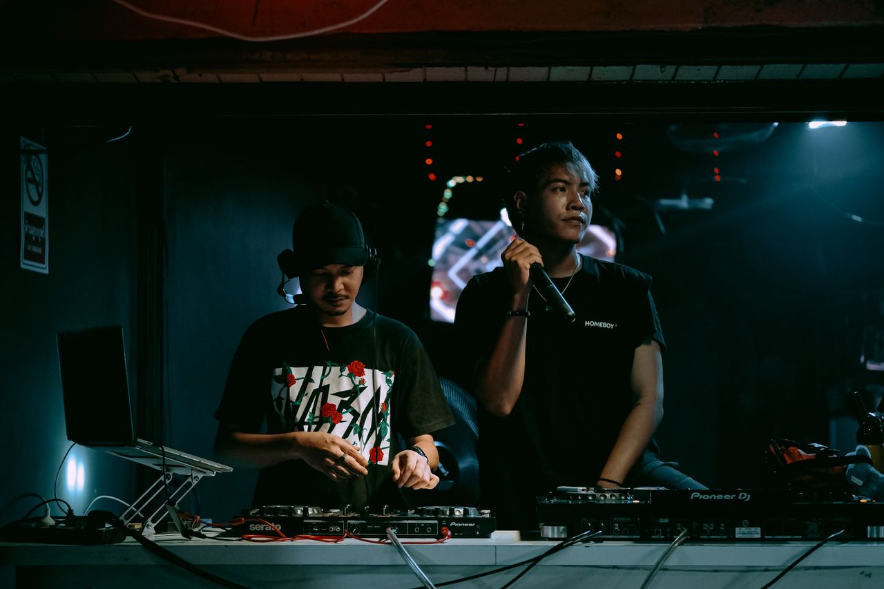 The Art of Drawing Readers In: Your attractive post title goes here Two DJs performing with equipment in a vibrant nightclub setting, exuding party vibes.